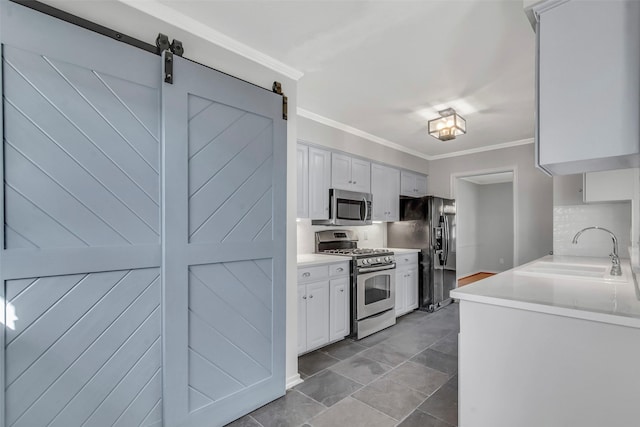 kitchen featuring a sink, appliances with stainless steel finishes, crown molding, and light countertops