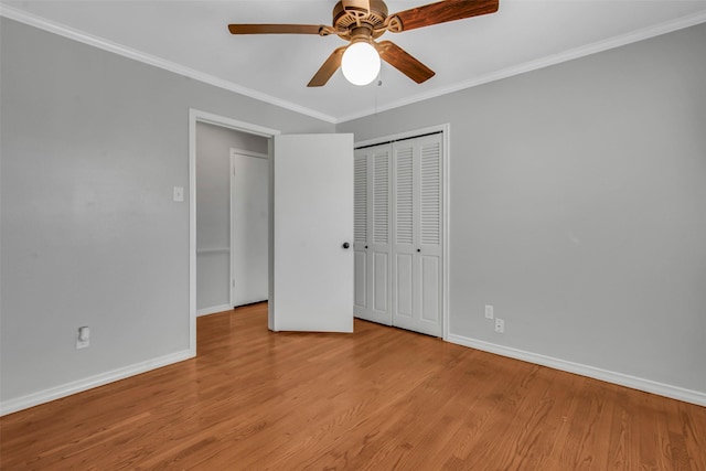 unfurnished bedroom featuring light wood-style flooring, baseboards, a closet, and ornamental molding