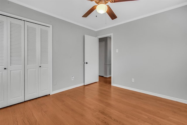 unfurnished bedroom featuring light wood-style floors, baseboards, a closet, and ornamental molding