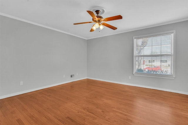 spare room featuring baseboards, crown molding, ceiling fan, and wood finished floors