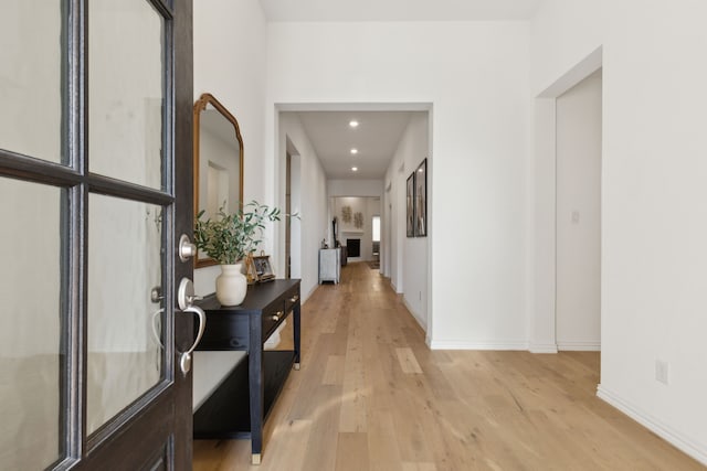 hallway featuring recessed lighting, baseboards, and light wood-style flooring