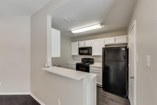 kitchen featuring visible vents, light countertops, dark wood-style floors, white cabinets, and black appliances