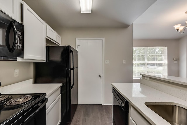 kitchen with black appliances, light stone countertops, a chandelier, dark wood-style floors, and white cabinetry