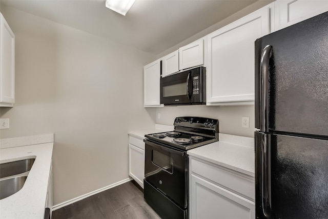 kitchen with white cabinetry, black appliances, light countertops, and dark wood-type flooring