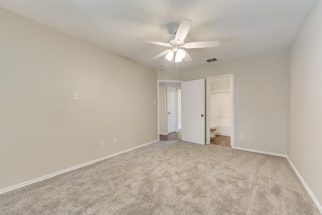 unfurnished bedroom with visible vents, baseboards, ceiling fan, carpet, and ensuite bath