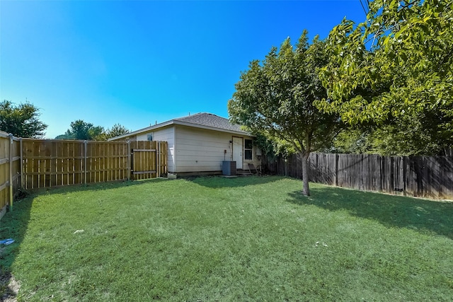 view of yard with central AC and a fenced backyard