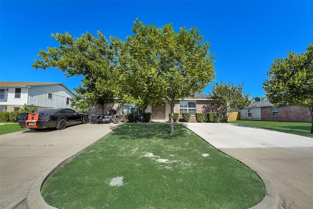 view of front of property with brick siding, concrete driveway, and a front yard