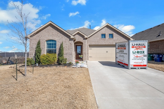 view of front of house with a garage, brick siding, and driveway