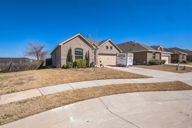 single story home with brick siding, an attached garage, and concrete driveway