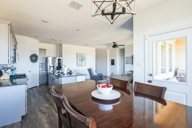 dining space featuring visible vents, a notable chandelier, and dark wood finished floors