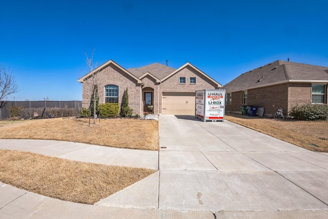 french provincial home featuring a garage, brick siding, and driveway