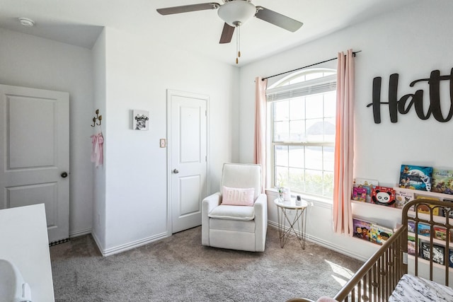 bedroom with a nursery area, baseboards, carpet, and a ceiling fan