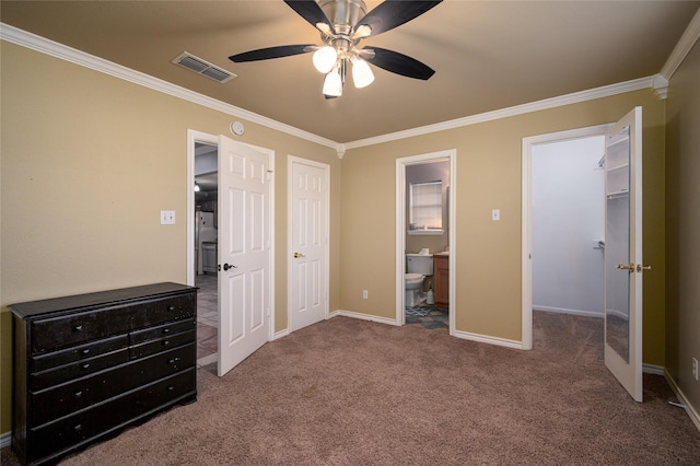 carpeted bedroom with visible vents, baseboards, a walk in closet, and crown molding