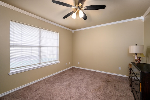 empty room with baseboards, dark carpet, ornamental molding, and a ceiling fan