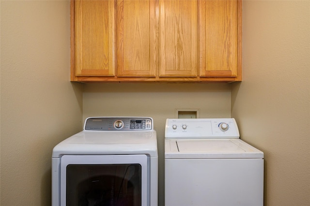 washroom with cabinet space and washing machine and clothes dryer