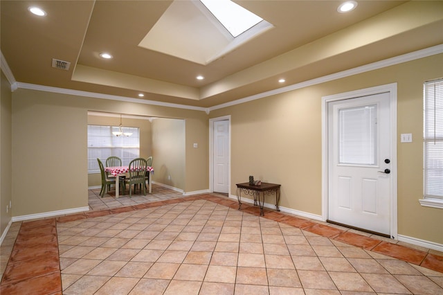 foyer with light tile patterned floors, visible vents, a tray ceiling, and ornamental molding