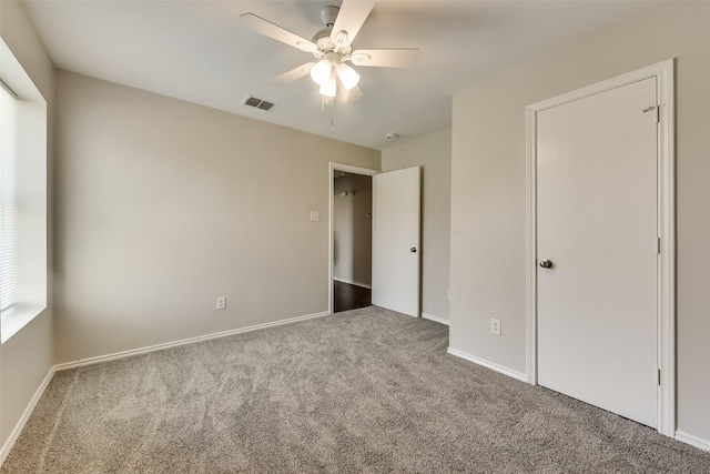 unfurnished bedroom with a ceiling fan, carpet, visible vents, and baseboards