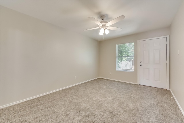 empty room with carpet flooring, baseboards, and ceiling fan