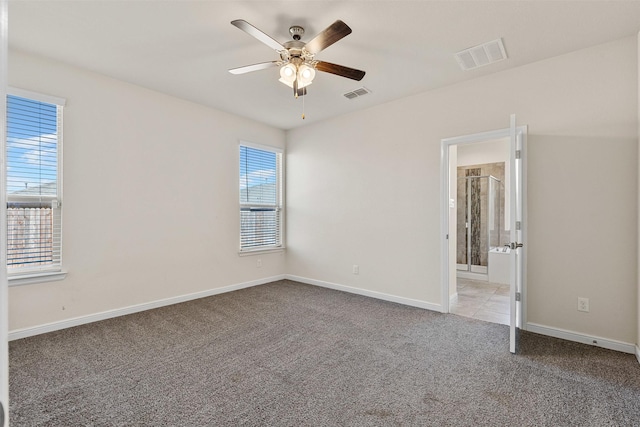 empty room with visible vents, baseboards, a ceiling fan, and carpet floors