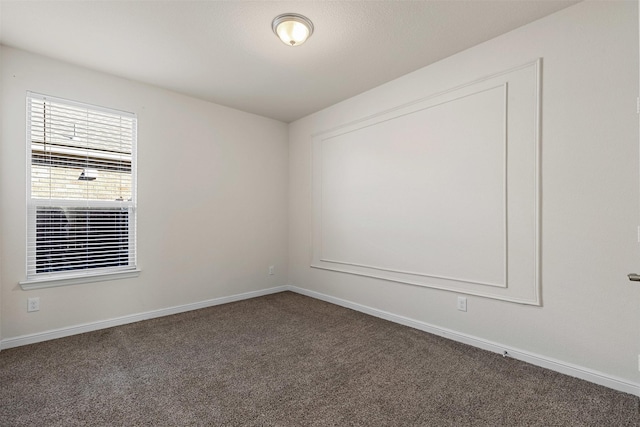 spare room featuring baseboards and carpet flooring