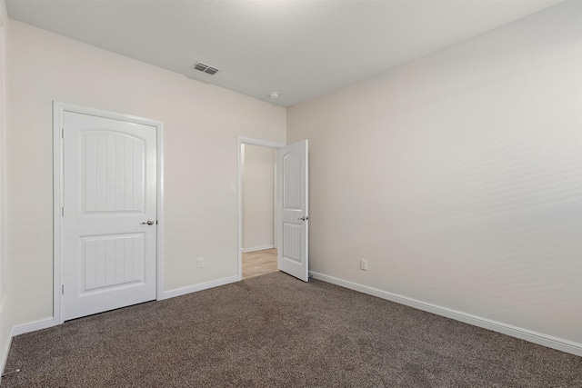 unfurnished bedroom featuring carpet, visible vents, and baseboards