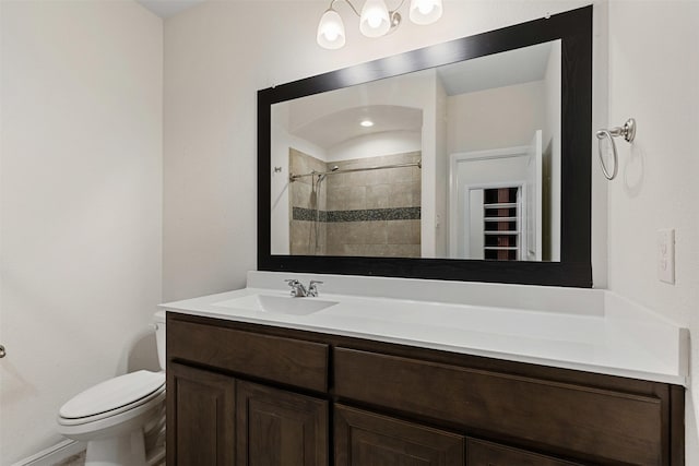 full bath with tiled shower, toilet, and vanity