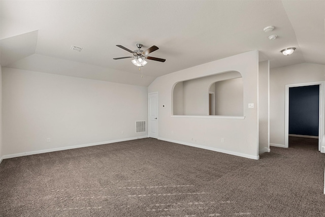 empty room featuring visible vents, lofted ceiling, carpet, and ceiling fan