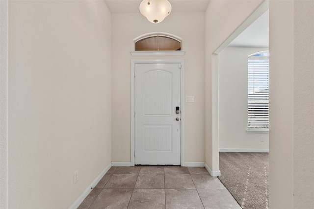 foyer entrance featuring tile patterned flooring and baseboards