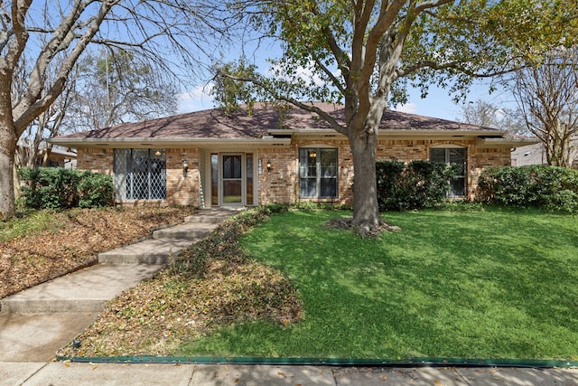 ranch-style home featuring a front yard and brick siding