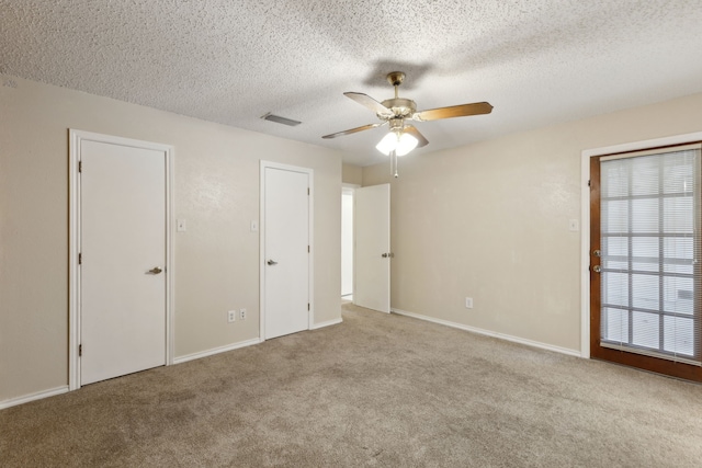 unfurnished bedroom featuring visible vents, carpet, and a textured ceiling