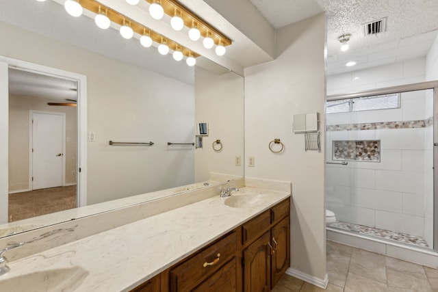 bathroom featuring a sink, visible vents, toilet, and a stall shower