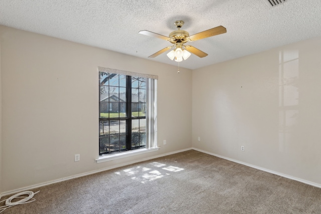 empty room featuring baseboards, a textured ceiling, a ceiling fan, and carpet