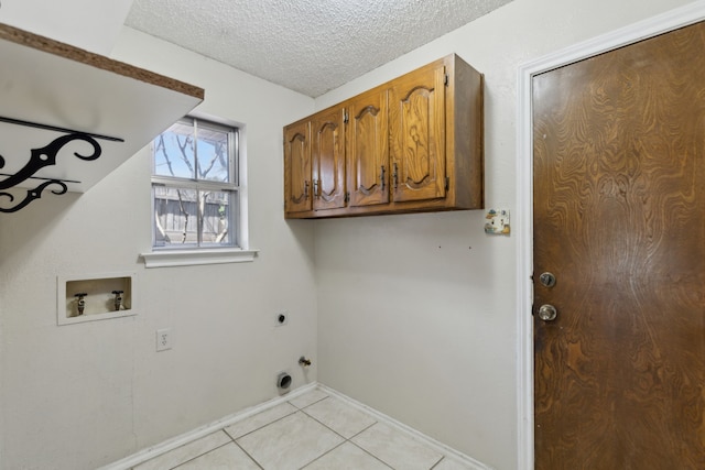 laundry room featuring light tile patterned floors, hookup for an electric dryer, cabinet space, washer hookup, and a textured ceiling