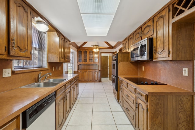 kitchen featuring a sink, brown cabinets, appliances with stainless steel finishes, and light tile patterned floors