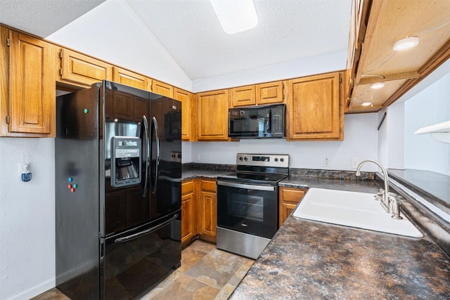 kitchen featuring dark countertops, vaulted ceiling, brown cabinetry, black appliances, and a sink