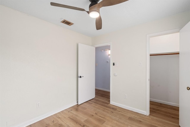 unfurnished bedroom with a ceiling fan, baseboards, visible vents, light wood finished floors, and a closet