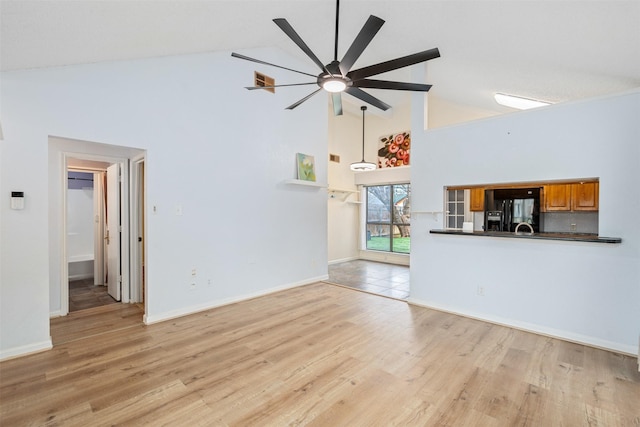 unfurnished living room with visible vents, high vaulted ceiling, light wood-style floors, and a ceiling fan