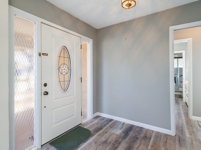 entryway featuring baseboards and wood finished floors