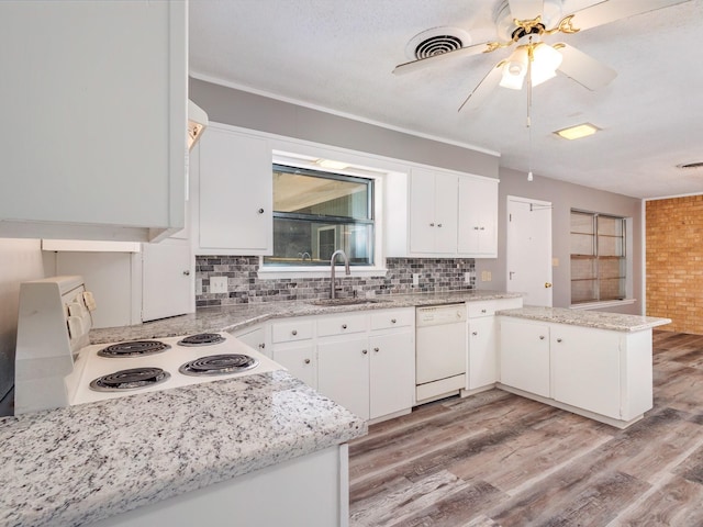 kitchen with visible vents, a sink, tasteful backsplash, a peninsula, and dishwasher