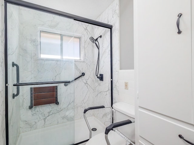 full bathroom with tile walls, toilet, and a marble finish shower