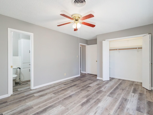 unfurnished bedroom with light wood-type flooring, visible vents, baseboards, and a closet