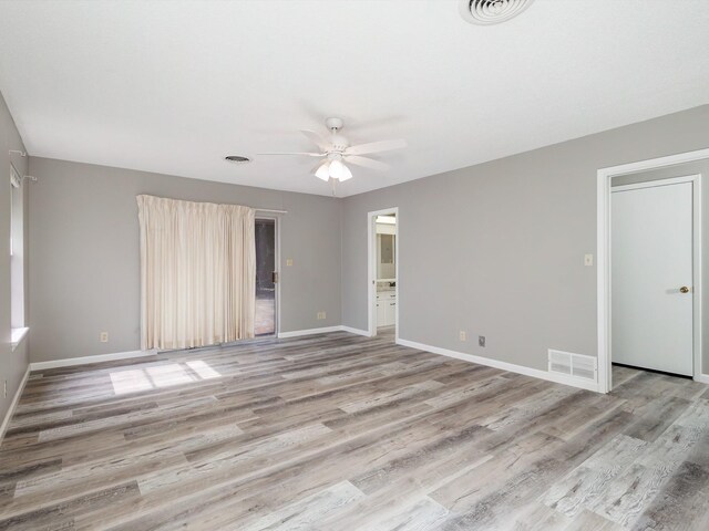 empty room with light wood-type flooring, visible vents, baseboards, and a ceiling fan