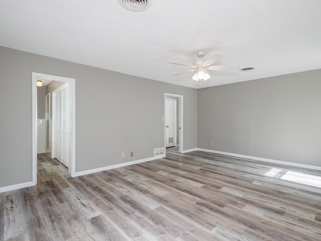 spare room with visible vents, baseboards, a ceiling fan, and wood finished floors