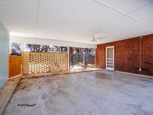 exterior space with a gate, fence, and ceiling fan