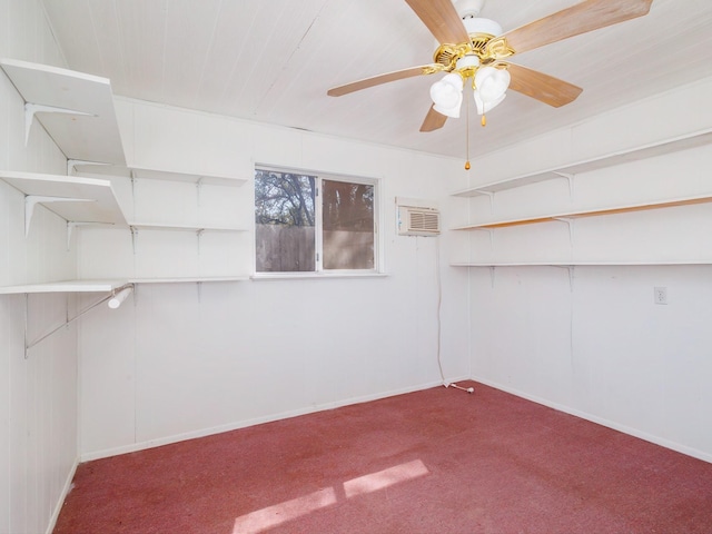 empty room featuring a wall unit AC, baseboards, ceiling fan, and carpet floors