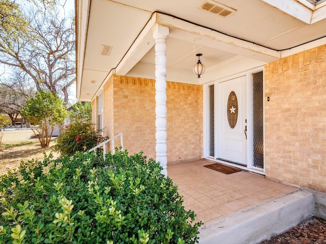 property entrance with visible vents and brick siding