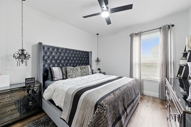 bedroom featuring a ceiling fan, wood finished floors, and baseboards