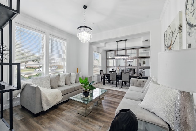 living room with an inviting chandelier, wood finished floors, and crown molding