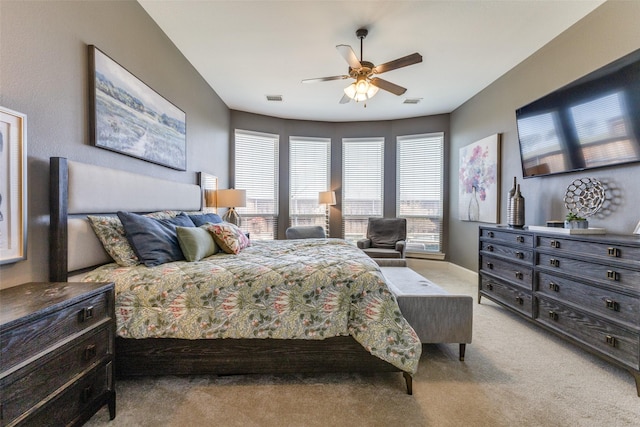 bedroom with ceiling fan, baseboards, visible vents, and light carpet