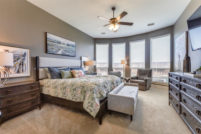 bedroom with visible vents, multiple windows, and light colored carpet